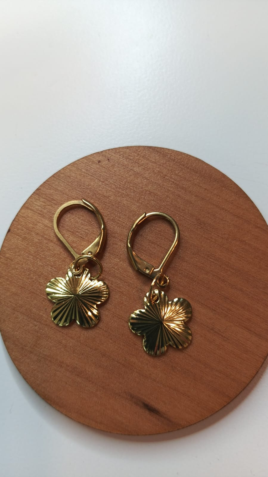 Aros dorados con forma de flor de 5 pétalos.